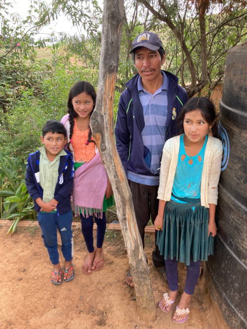 Andres und seine drei Kinder neben dem neu installierten Tank.